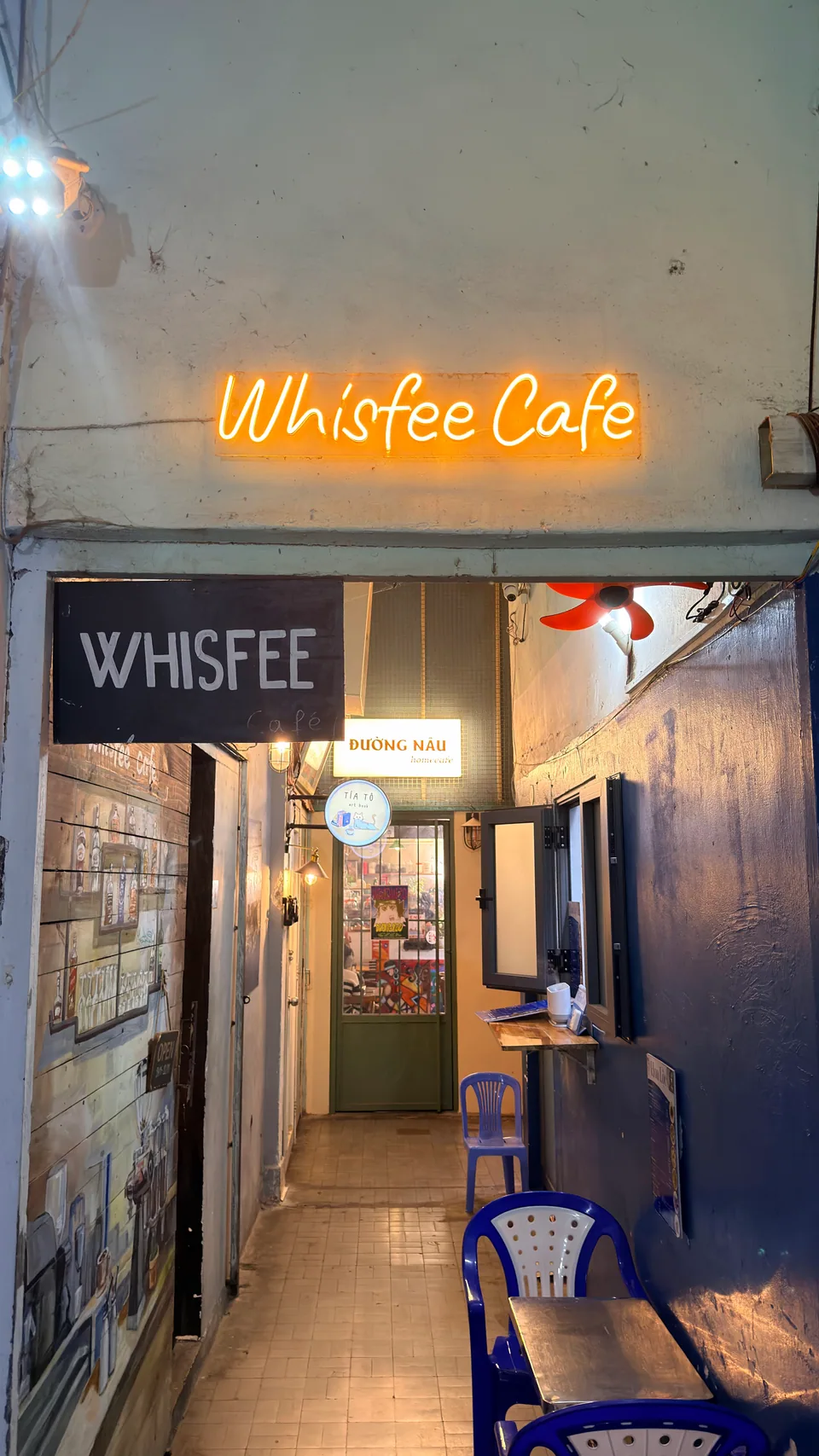 Lối vào Whisfee Café với biển neon màu cam trong hẻm Tôn Thất Đạm
